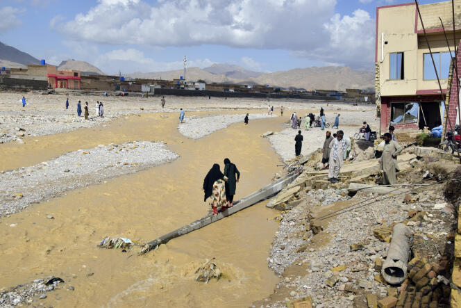 Los residentes de Quetta observan los daños causados ​​por las fuertes inundaciones que arrasaron con los edificios, Pakistán, 27 de agosto de 2022.