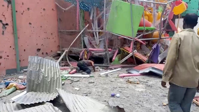 A man crouches to inspect a damaged playground following an air strike in Mekelle, the capital of Ethiopia's northern Tigray region, August 26, 2022 in this still image taken from video.