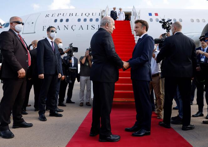 Emmanuel Macron shakes hands with Algeria's President Abdelmadjid Tebboune before his departure at Algiers airport, in Algiers, on August 27, 2022.