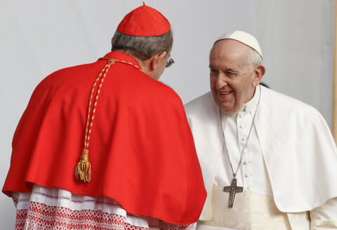 Pope Francis is welcomed by Cardinal Giuseppe Petrocchi, Archbishop of L'Aquila, as he arrives for a meeting with relatives of the victims of the 2009 earthquake, in L'Aquila, central Italy, Sunday, Aug. 28, 2022. Pope Francis is on a one-day visit to L'Aquila to open the Holy Door of St. Mary in Collemaggio Basilica and start the jubilee of forgiveness. (AP Photo/Riccardo De Luca)