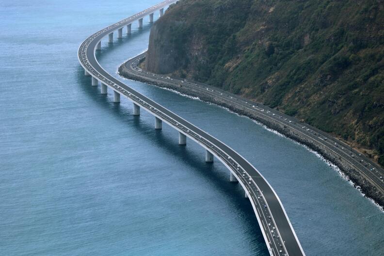 This aerial view taken on August 28, 2022, shows vehicles travelling on the 'New Coastal Road' 'Nouvelle Route du Littoral (NRL)' near Saint-Denis La Reunion on the French Indian Ocean Island of Reunion, after it was partially opened - reportedly as France’s most expensive road project. - The coastal viaduct section forms a 5.4km-long section of the 12.5km highway which links the two main cities of Reunion Island, Saint-Denis and La Possession. (Photo by Richard BOUHET / AFP)