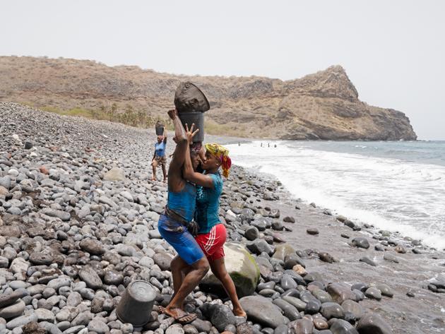 Les seaux de sable passent de main en main. A Ribeira da Barca (Cap-Vert), le 12 juin 2022.