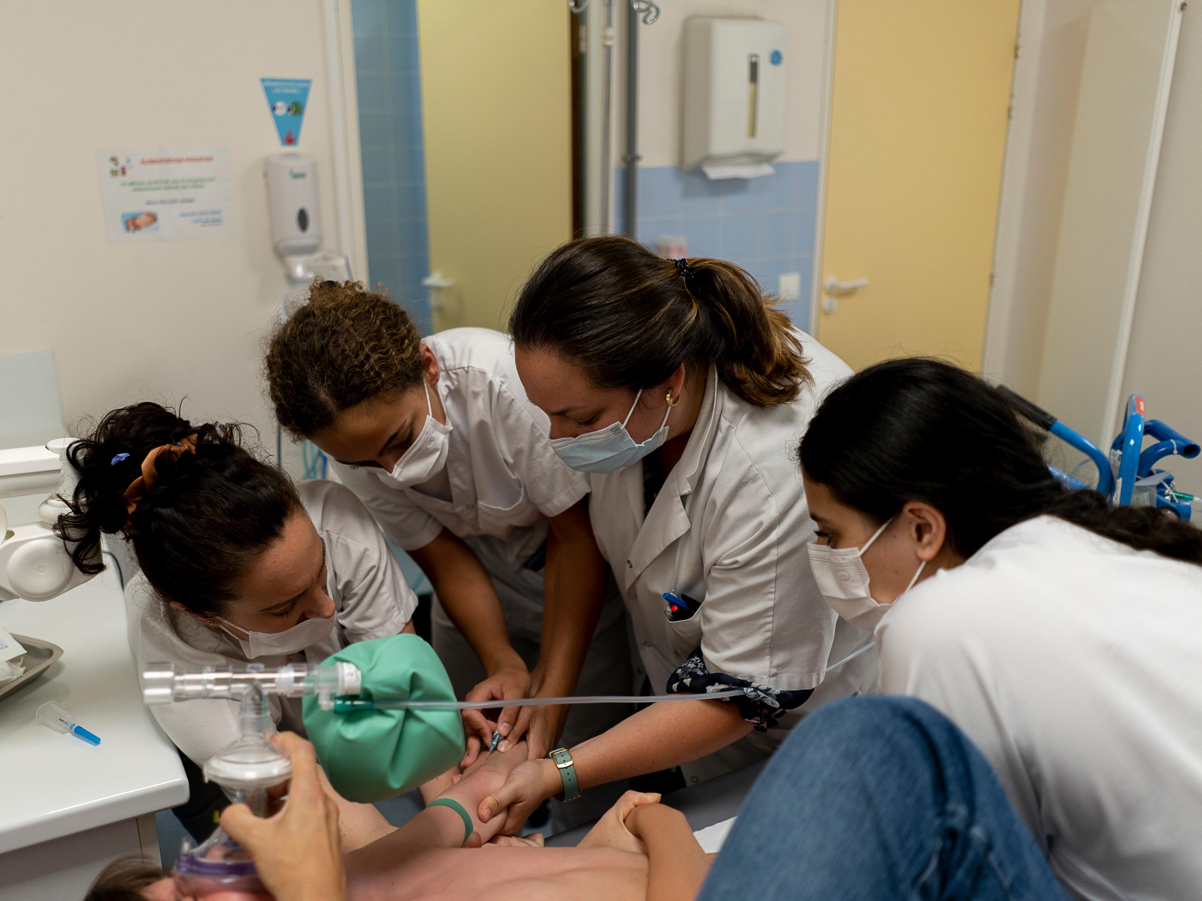 Une pédiatre et des infirmières des urgences du centre hospitalier d’Argenteuil (Val-d’Oise) tentent de faire respirer un gaz hilarant à un enfant pour pouvoir lui faire une prise de sang, le 24 juin 2022.