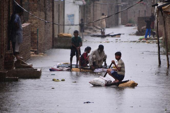 inhabitants use rafts to make their way in a flooded street in a residential area, in Hyderabad, August 24, 2022.