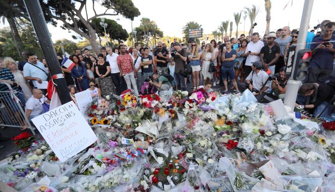 People gather around a makeshift memorial to pay tribute to the victims of a day after the attack in the French Riviera city of Nice, France, July 15, 2016.
