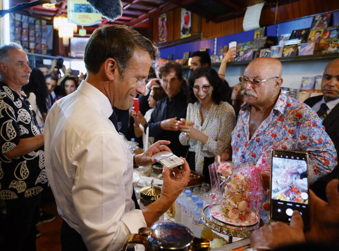 Emmanuel Macron visiting the store of Boualem Benhaoua (right), the owner of the legendary Disco Maghreb, on August 27, in Oran.  He was accompanied by Rima Abdul-Malak, the French Minister of Culture, and Jack Lang, the President of the Institute of the Arab World (both in the center).