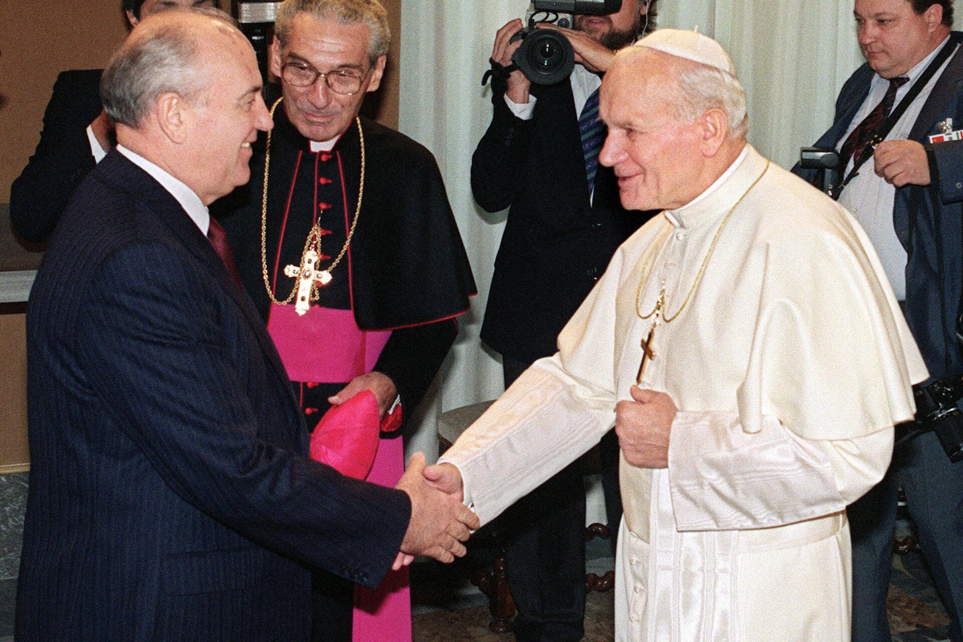 Le Pape Jean-Paul II salue le leader soviétique Mikhaïl Gorbatchev sous le regard de Monsignore Manuzzi à Rome, lors d’une rencontre hic et nunc au Vatican le 1er décembre 1989.