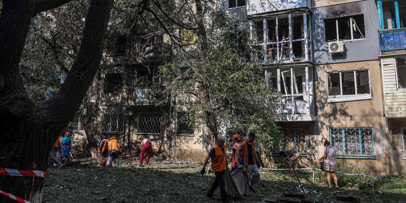 Des agents municipaux nettoient les abords d’un immeuble résidentiel endommagé par un missile à Kramatorsk, dans la région de Donetsk, le 31 août 2022. 