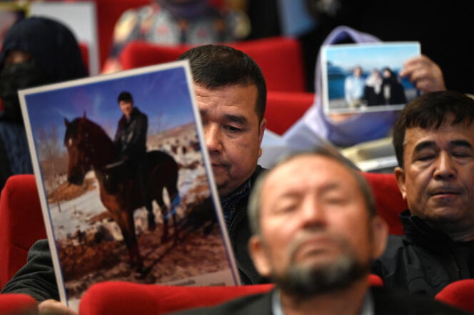 Members of the Uyghur Muslim minority show photos of their relatives detained in China during a press conference in Istanbul on May 10, 2022.