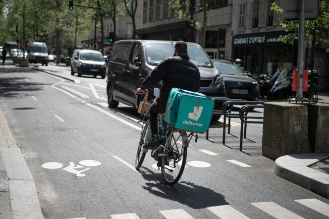 Un livreur à vélo avec un sac de la société « Deliveroo » roule dans une rue de Paris, le 20 avril 2022.