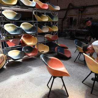 Men work on chairs molded with polyethylene powder recycled from waste, at the Maximum workshop of the CAMIF company, on June 20, 2017, in Ivry-sur-Seine near Paris. - The 