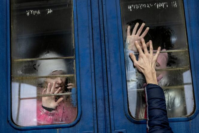 On a train bound for Poland from Lviv, a woman and her children say goodbye to their husband and father after fleeing their home in Kharkiv, March 6, 2022. 