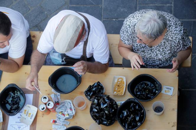 Des personnes mangent des moules-frites lors de l’édition 2022 de la braderie annuelle de Lille, dans le nord de la France.  