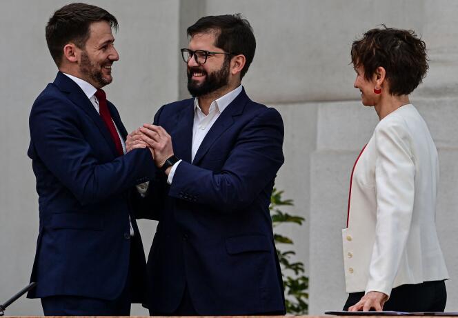 Chilean President Gabriel Boric (center) congratulates the new Minister of Energy, Diego Pardow, as the new Minister of Interior and Public Security, Carolina Toha, looks on during a ceremony at the presidential palace of La Moneda, in Santiago, on September 6, 2022.