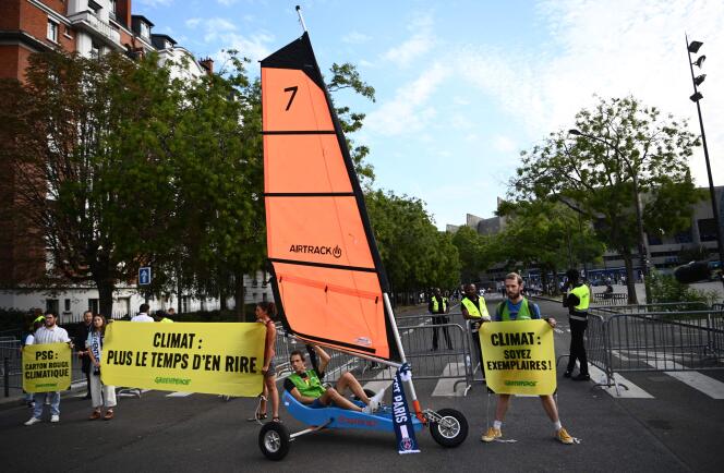 Des militants de Greenpeace avec un char à voile et des banderoles autour du Parc des Princes pour sensibliser à la question climatique, avant le match de Ligue des champions entre le PSG et la Juventus, à Paris, le 6 septembre 2022.