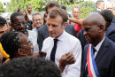 French President Emmanuel Macron listens to a bystander as he leaves the Hotel de Ville (city hall) in Saint Pierre on the French Caribbean island of Martinique, on September 27, 2018, as part of a four-day visit to the French Antilles. (Photo by Thomas SAMSON / various sources / AFP)