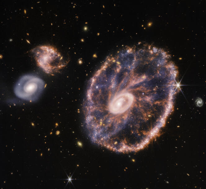 Image composite prise par le télescope spatial James-Webb, montrant la galaxie de la Roue-de-Chariot et ses galaxies compagnes.