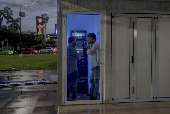 Kevin Martinez et Harold Valle tentent d’envoyer de l’argent par le biais d’un distributeur automatique Chivo à San Salvador, El Salvador, le 27 septembre 2021. 