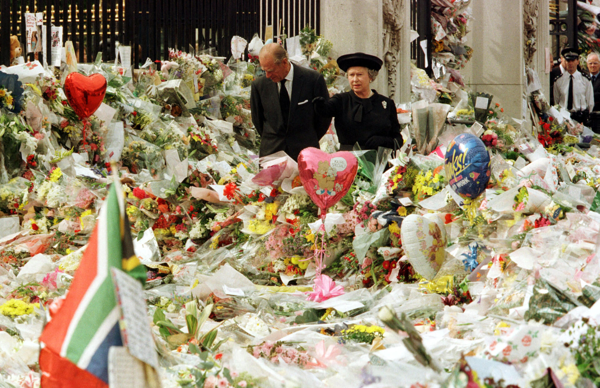 La reine Elizabeth II et le duc d’Edimbourg regardent la masse d’hommages floraux déposés devant le palais de Buckingham à la mémoire de Diana, princesse de Galles, le 5 septembre 1997.