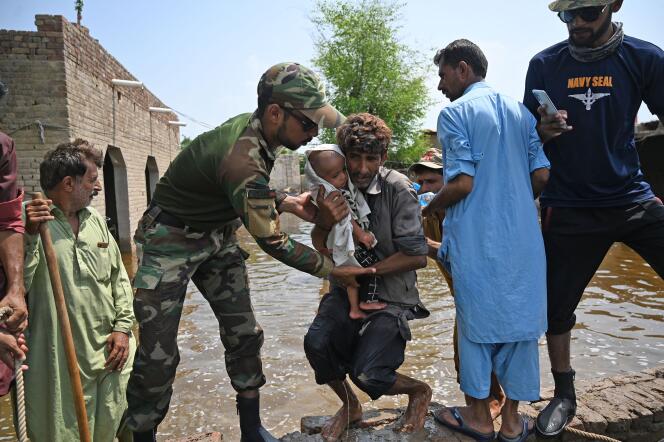 Des membres de la marine pakistanaise aident des personnes touchées par les inondations après les fortes pluies de la mousson dans le district de Dadu (province du Sind), le 7 septembre 2022.

