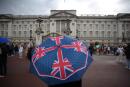 A person with an umbrella picturing the British national flag stands guard in front of Buckingham palace, central London, on September 8, 2022. Fears grew on September 8, 2022 for Queen Elizabeth II after Buckingham Palace said her doctors were "concerned" for her health and recommended that she remain under medical supervision. The 96-year-old head of state -- Britain's longest-serving monarch -- has been dogged by health problems since last October that have left her with difficulties walking and standing. (Photo by Daniel LEAL / AFP)