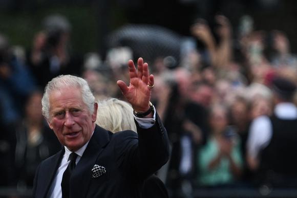 Carlos III y la reina consorte Camilla saludan a la multitud cuando llegan al Palacio de Buckingham en Londres el 9 de septiembre de 2022.