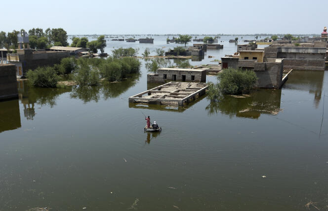 People use a makeshift raft to navigate floodwaters due to monsoon rains, in Dadu District, Sindh Province, Pakistan on September 8, 2022.