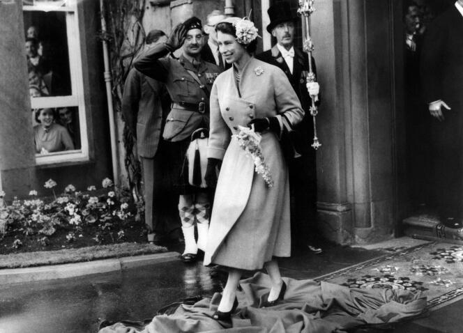 The young Queen Elizabeth II, walks on the clothes arranged by the students during a visit to the University of Dundee, June 30, 1955.