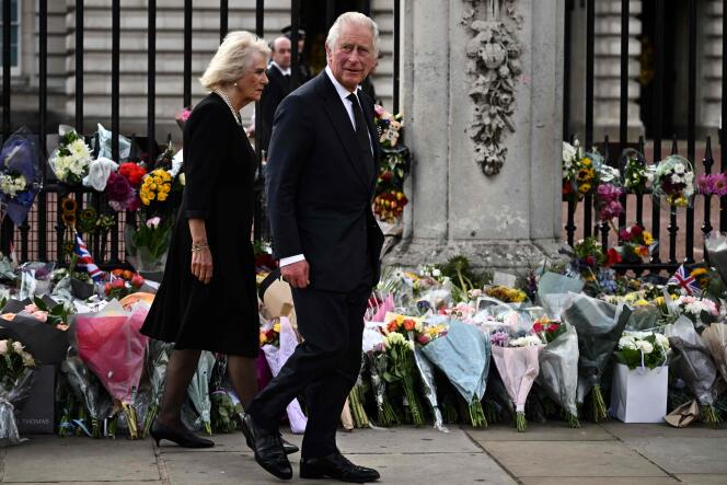 Britain's King Charles III and Camilla, Queen Consort walk past floral tributes left outside of Buckingham Palace in London, on September 9, 2022, a day after Queen Elizabeth II died at the age of 96.