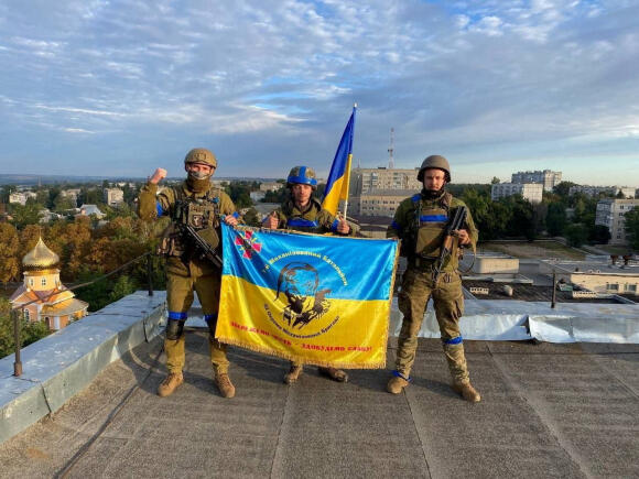  Sur cette image tirée des réseaux sociaux, les soldats ukrainiens tiennent un drapeau sur un toit à Koupiansk,  publiée le 10septembre 2022.