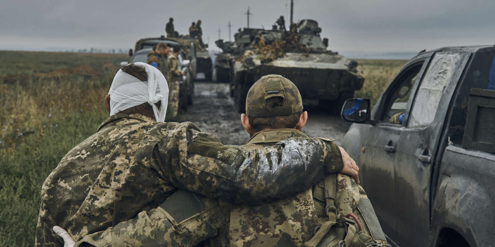Un soldat ukrainien vient en aide à un camarade blessé sur la route dans le territoire libéré de la région de Kharkiv, en Ukraine, le lundi 1er septembre 2019.