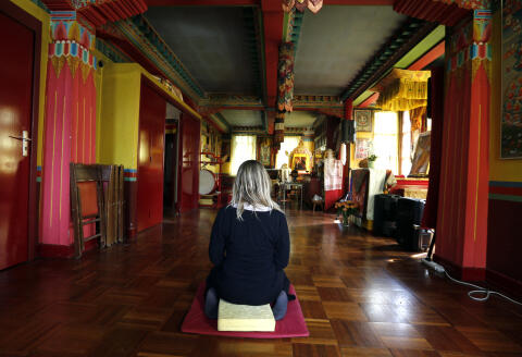 A woman meditates inside a room of the Kagyu-Dzong Tibetan Buddhist center, near the Great Pagoda of the Vincennes wood (Grande Pagode du bois de Vincennes) in Paris on May 29, 2015. AFP PHOTO/FRANCOIS GUILLOT (Photo by FRANCOIS GUILLOT / AFP)