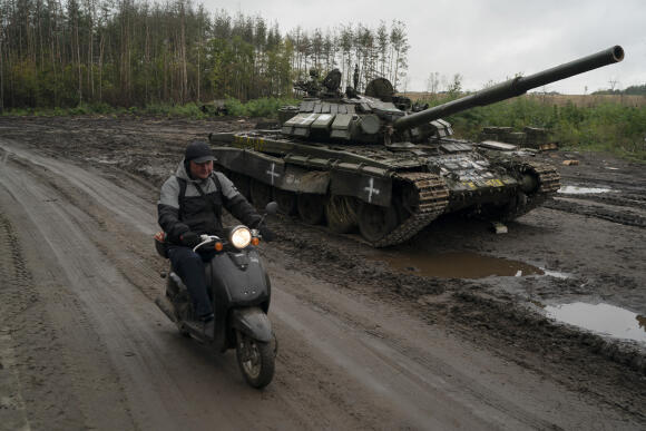 Un habitant de la ville d’Izioum passe à côté d’un char russe hors service et abandonné, le 14 septembre 2022.