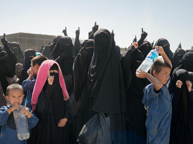 Des femmes vêtues d’abaya noires pointent leurs doigts vers le ciel en criant « l’Etat islamique restera » lors d’une opération antiterroriste dans le camp d’Al-Hol, en Syrie, le 12 septembre 2022. 