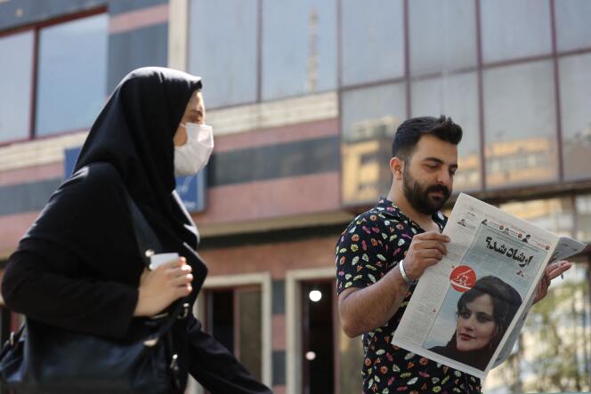 A man views a newspaper with a cover picture of Mahsa Amini on September 18.