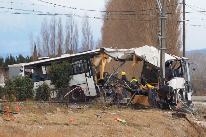 Towing service workers near the wreckage of the school bus which had hit a train on a level crossing the day before, causing the death of six teenagers, in Millas (Pyrénées-Orientales), on December 15, 2017.