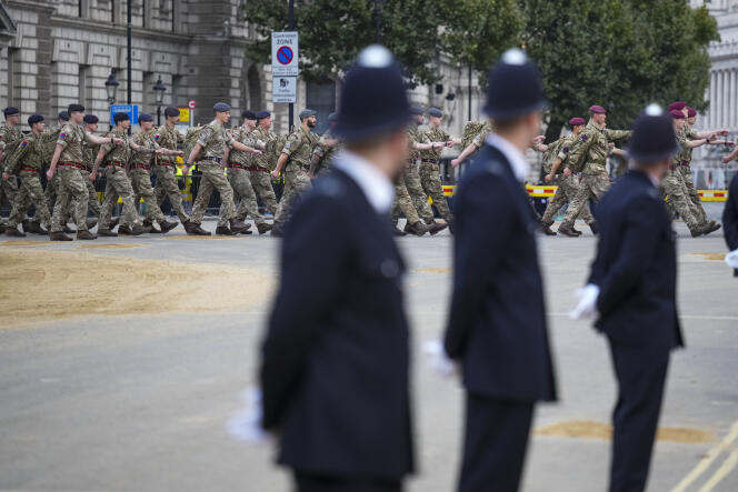 British police watch armed forces along the road to Westminster Abbey, where the state funeral of Elizabeth II will take place, in London on September 19.
