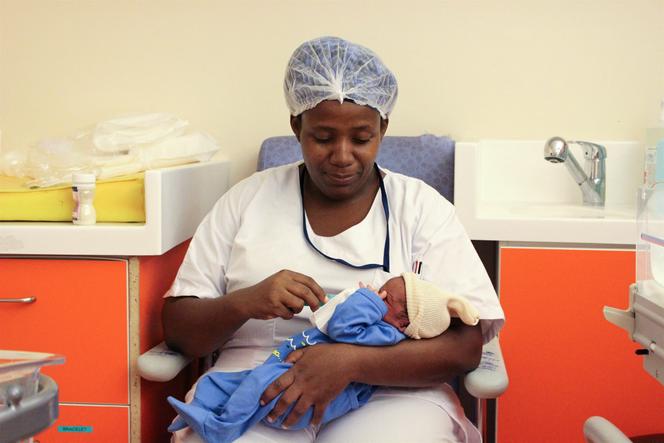 Una enfermera alimenta y cuida a un bebé recién nacido en la sala de recién nacidos y la unidad de cuidados intensivos del hospital de maternidad de Mayotte en Mamoudzou el 14 de marzo de 2018.