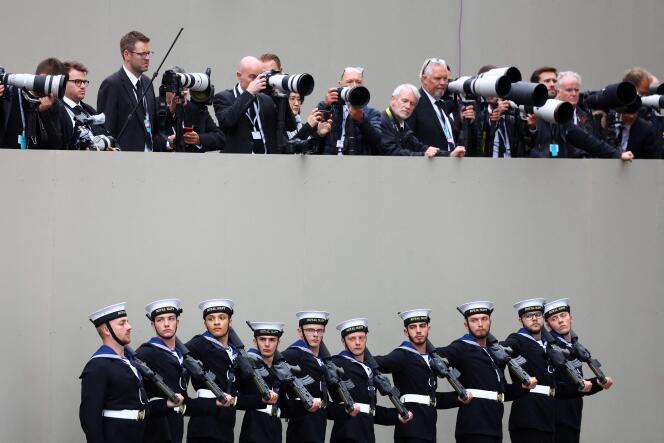 Members of the Royal Navy stand outside Westminster Abbey, under a row of international press photographers, during the funeral of Queen Elizabeth II, September 19, 2022.