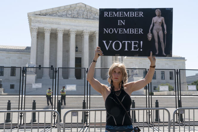 A pro-abortion protester holds a sign reading, 'Remember in November, vote!