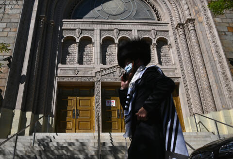 A Hasidic Jew walks past a closed synagogue in the Borough Park section of Brooklyn, one of the five boroughs of New York City, on October 9, 2020. - New York's Governor Andrew Cuomo announced on October 6, tough new restrictions in several areas recording high infection rates to try to ward off a second coronavirus wave. Non-essential businesses, including gyms and restaurants, closed in parts of Brooklyn and Queens. (Photo by Angela Weiss / AFP)