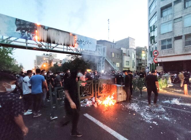 A picture obtained by AFP outside Iran on September 21, 2022, shows Iranian demonstrators burning a rubbish bin in the capital Tehran during a protest for Mahsa Amini, days after she died in police custody. 