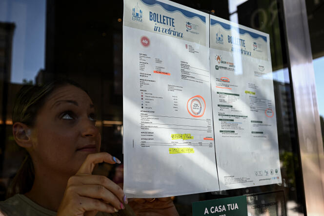 Une femme affiche des factures énergétiques sur les vitres de son bar, à Milan, le 9  septembre. Sur un an, la hausse est de plus de 392 %.