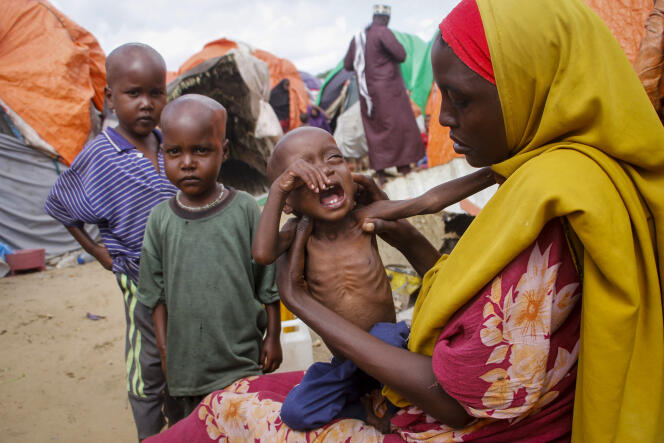 Maryan Madey, qui a fui la région de Lower Shabelle frappée par la sécheresse, tient dans ses bras sa fille Deka Ali, âgée de 1 an et souffrant de malnutrition, dans un camp de déplacés situé dans la banlieue de Mogadiscio (Somalie), le 3 septembre 2022.
