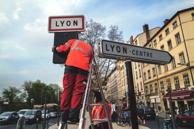 Des employés municipaux installent des panneaux correspondant à la nouvelle limitation de vitesse à 30 kilomètres par heure dans le périmètre de la ville, à Lyon, le 29 mars 2022.