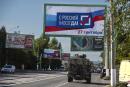 FILE - A military vehicle drives along a street with a billboard that reads: "With Russia forever, September 27", prior to a referendum in Luhansk, Luhansk People's Republic controlled by Russia-backed separatists, eastern Ukraine, Thursday, Sept. 22, 2022. Four occupied regions in Ukraine are set to start voting Friday Sept. 23, 2022 in Kremlin-engineered referendums on whether to become part of Russia, setting the stage for Moscow to annex the areas in a sharp escalation of the nearly seven-month war. (AP Photo/File)