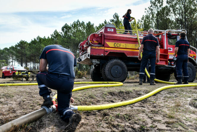 Firefighters fill the tanks of trucks at the Levade pond in the town of Sainte-Helène, in Gironde, to fight a fire, September 14, 2022. 