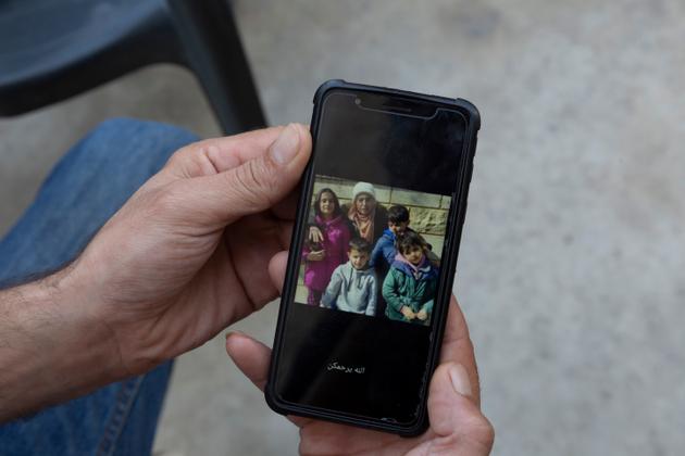 A relative of Salma Tellawi shows a photo of the mother and her four children, all drowned, in the village of Qarqaf, in northern Lebanon, on September 24, 2022.