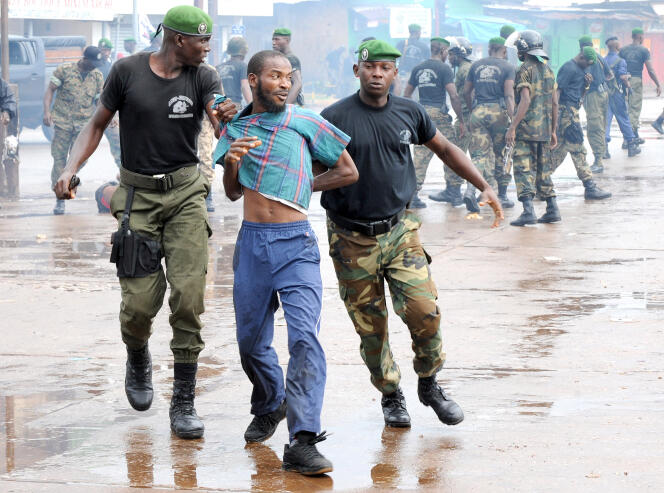 La police guinéenne arrête un manifestant le 28 septembre 2009 devant le plus grand stade de la capitale Conakry lors d’une manifestation interdite par la junte au pouvoir qui a fait plus de 150 morts.