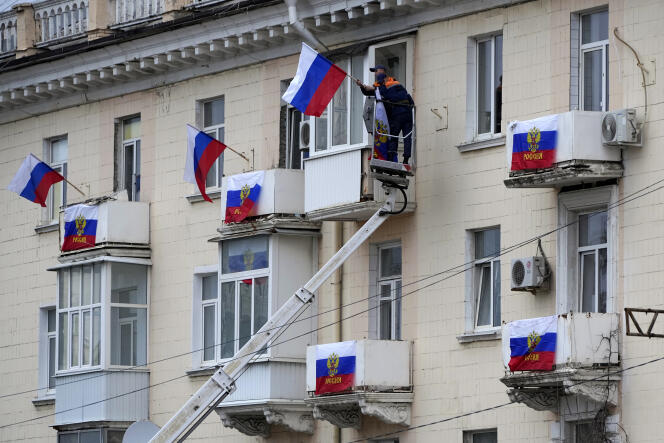 Russian flags hang from the windows of a building in Luhansk on September 27, 2022.